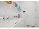 Well-equipped laundry room with washer, dryer, and ample storage shelving at 9566 Coastline Way, Parrish, FL 34219