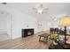 Bright open-concept living room featuring wood floors and a modern fireplace, adjacent to the kitchen and dining area at 9566 Coastline Way, Parrish, FL 34219