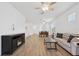 Spacious living room with wood floors, fireplace, comfortable seating, and a view into the dining area at 9566 Coastline Way, Parrish, FL 34219