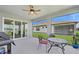 Relaxing screened patio with ceiling fan, table, and grill, perfect for outdoor dining at 9566 Coastline Way, Parrish, FL 34219