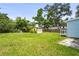Large backyard featuring a shed, green grass, and mature trees at 1008 37Th W St, Bradenton, FL 34205