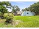Large backyard featuring a shed, green grass, and mature trees at 1008 37Th W St, Bradenton, FL 34205