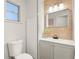 Modern bathroom featuring grey vanity with bronze hardware, a custom mirror and white toilet at 1008 37Th W St, Bradenton, FL 34205