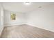 A bright, updated room with hardwood floors, white walls and trim and a large window at 1008 37Th W St, Bradenton, FL 34205