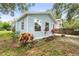 Corner view of a light blue home with well-maintained landscaping and vibrant tropical plants at 1008 37Th W St, Bradenton, FL 34205