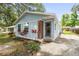 Charming light blue home featuring a landscaped yard and inviting front door with vertical wood accent at 1008 37Th W St, Bradenton, FL 34205