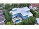 Aerial view of a stunning luxury home with a pool, patio, and lush landscaping at 1076 Toc0Baga, Sarasota, FL 34234
