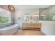 Luxurious bathroom featuring double sinks, a soaking tub, and elegant fixtures at 1076 Toc0Baga, Sarasota, FL 34234