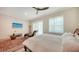 Well-lit bedroom with wood flooring, chic furniture, large windows with sheer curtains, and a modern ceiling fan at 1076 Toc0Baga, Sarasota, FL 34234