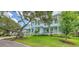 Expansive light blue home with a manicured lawn and mature trees at 1076 Toc0Baga, Sarasota, FL 34234