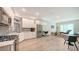 Bright open-concept kitchen area with stainless appliances, sleek white cabinets, and light wood-look flooring at 1076 Toc0Baga, Sarasota, FL 34234