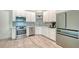 Modern kitchen featuring stainless steel appliances, white cabinetry, light countertops, and herringbone backsplash at 1076 Toc0Baga, Sarasota, FL 34234