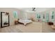 Well-lit main bedroom with a large mirror, neutral tones, and multiple windows overlooking lush greenery at 1076 Toc0Baga, Sarasota, FL 34234