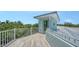 Inviting rooftop deck with white railings, weathered wood flooring, and shaded views of the surrounding mature trees at 1076 Toc0Baga, Sarasota, FL 34234
