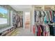 Spacious walk-in closet with custom shelving and storage, complemented by bright, patterned wallpaper at 1076 Toc0Baga, Sarasota, FL 34234