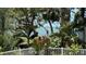 Breathtaking water view from a property, framed by lush tropical foliage and a white fence at 1076 Toc0Baga, Sarasota, FL 34234