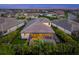 Aerial view of home with a screened-in pool and spa, surrounded by manicured landscaping and a neighborhood at 11422 Apple Tree Cir, Bradenton, FL 34211