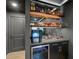 Stylish bar area with shelves, cabinets, granite countertop, small refrigerator, and a sink at 11422 Apple Tree Cir, Bradenton, FL 34211