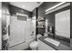 Modern bathroom with dark gray walls, a white tiled shower, and sleek fixtures at 11422 Apple Tree Cir, Bradenton, FL 34211