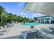Upscale community pool area with lounge chairs, shade, and a modern pool house with bar seating at 11422 Apple Tree Cir, Bradenton, FL 34211