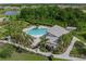 Aerial view of the community pool with a unique heart shape, surrounded by palm trees and green spaces at 11422 Apple Tree Cir, Bradenton, FL 34211