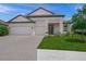 Charming home exterior with a well-manicured lawn, paver driveway, two-car garage, and lovely landscaping at 11422 Apple Tree Cir, Bradenton, FL 34211
