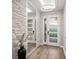 Light foyer with contemporary chandelier, large mirror, and textured stone wall at 11422 Apple Tree Cir, Bradenton, FL 34211