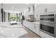 Modern kitchen with stainless appliances, a large island, and views into the dining area at 11422 Apple Tree Cir, Bradenton, FL 34211
