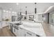 Open concept kitchen with a waterfall island, stainless steel appliances, and modern lighting at 11422 Apple Tree Cir, Bradenton, FL 34211