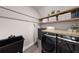 This laundry room features a sleek front-loading washer and dryer with a gray utility sink at 11422 Apple Tree Cir, Bradenton, FL 34211