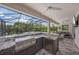 Outdoor kitchen and bar area with stainless steel appliances, granite counters, and a screened lanai at 11422 Apple Tree Cir, Bradenton, FL 34211
