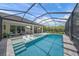 Backyard screened-in pool with a spa and lounge chairs, surrounded by lush landscaping at 11422 Apple Tree Cir, Bradenton, FL 34211