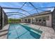 Backyard screened-in pool with a spa and lounge chairs, surrounded by lush landscaping at 11422 Apple Tree Cir, Bradenton, FL 34211