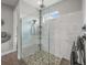 Walk-in shower featuring marble tiling, a rain shower head, and a built-in shelving unit at 11422 Apple Tree Cir, Bradenton, FL 34211