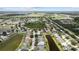 Aerial view of home, neighborhood, ponds, mature trees and landscaping; aerial view of city in the distance at 11839 Shrewsbury Ln, Parrish, FL 34219