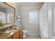 Well-lit bathroom with granite countertops, tiled flooring, and a decorative shower curtain at 11839 Shrewsbury Ln, Parrish, FL 34219