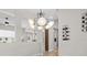 Elegant dining room with contemporary chandelier and wine storage on the wall at 11839 Shrewsbury Ln, Parrish, FL 34219