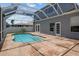 Backyard pool with stairs and beautiful stone-tiled surround with access to the home through french doors at 11839 Shrewsbury Ln, Parrish, FL 34219