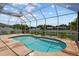 Screened-in pool with access steps, surrounded by tile and featuring views of the lushly landscaped backyard at 11839 Shrewsbury Ln, Parrish, FL 34219