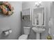 This powder room is updated with a decorative mirror, vanity cabinet, and lovely decorative wreath at 11839 Shrewsbury Ln, Parrish, FL 34219