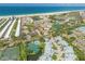 Stunning aerial view of a coastal community with beach access, tennis courts, and multiple swimming pools at 1240 Siesta Bayside Dr # 1240C, Sarasota, FL 34242