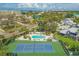 Aerial view of the community featuring a pool and tennis courts surrounded by trees and neighborhood homes at 1240 Siesta Bayside Dr # 1240C, Sarasota, FL 34242