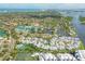 Aerial view of a coastal neighborhood with waterfront homes, canals, and tennis courts at 1240 Siesta Bayside Dr # 1240C, Sarasota, FL 34242