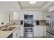 Modern kitchen with white cabinets, stainless steel appliances, and granite countertops at 1240 Siesta Bayside Dr # 1240C, Sarasota, FL 34242
