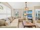 Cozy living room featuring a comfortable sectional sofa, natural light, and light hardwood floors at 1240 Siesta Bayside Dr # 1240C, Sarasota, FL 34242
