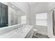 Bathroom with double sink, a large illuminated mirror and a shower with designer tile detail at 12814 Daisy Pl, Bradenton, FL 34212