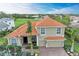 Beautiful two-story home featuring a tile roof, arched windows, and a lush, tropical landscape at 12814 Daisy Pl, Bradenton, FL 34212