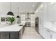 Modern kitchen features white cabinets, stainless appliances, and an expansive island with seating at 12814 Daisy Pl, Bradenton, FL 34212