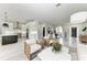 Bright open-concept living area flows into kitchen, featuring modern furniture and large windows at 12814 Daisy Pl, Bradenton, FL 34212