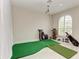 Room with putting green, screen, projector, and golf equipment for entertainment and practice at 12814 Daisy Pl, Bradenton, FL 34212